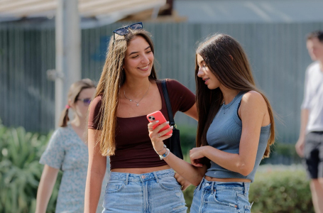 Two girls looking at social media on mobile phones